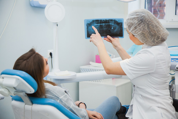 A woman reviewing her xray with a dentist.